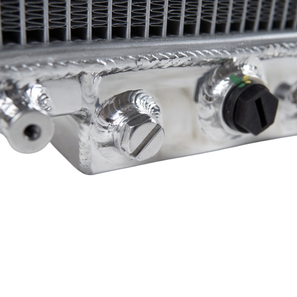 Close-up of a metallic radiator with control knobs on a white background