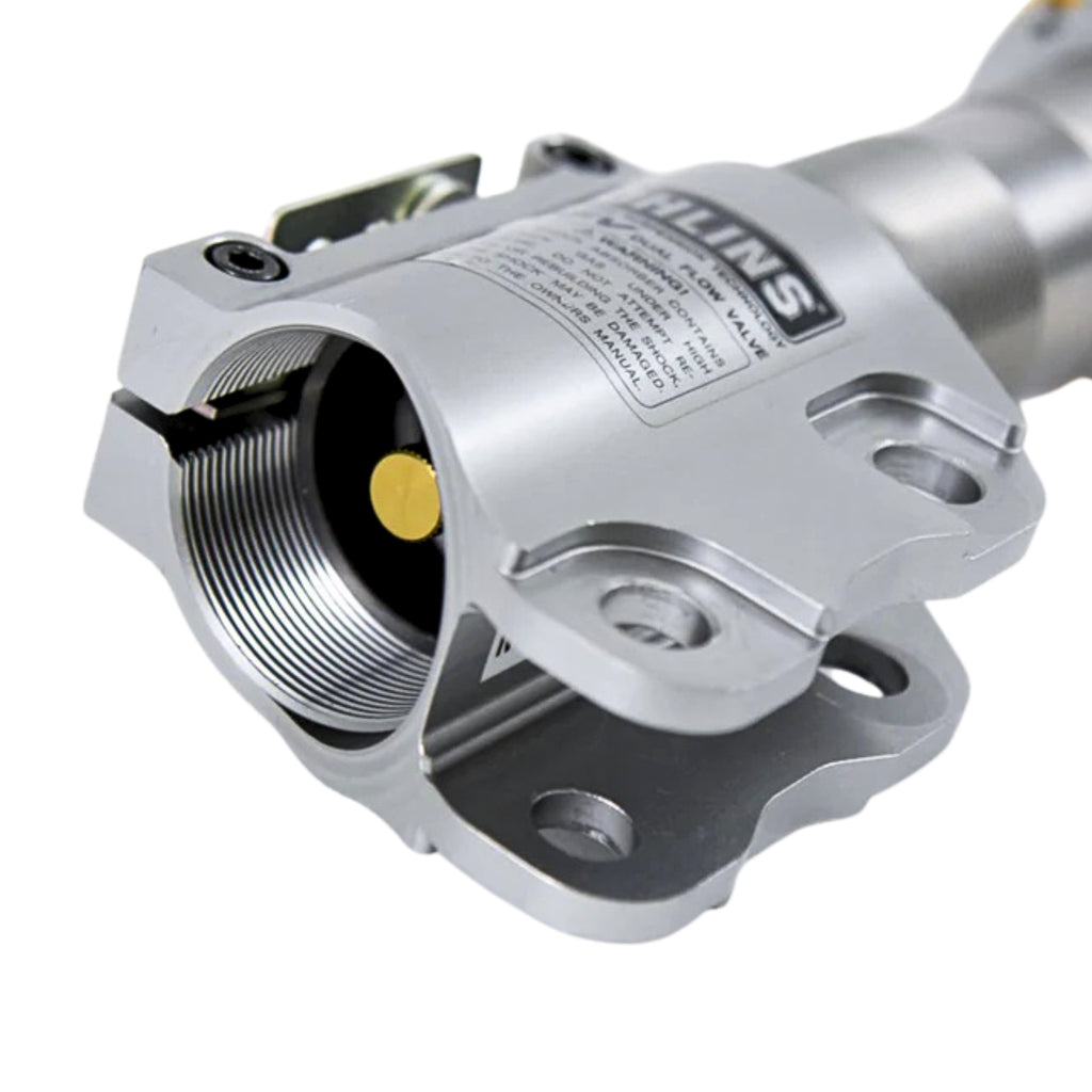 Close-up of a metallic mechanical component with 'Ohlins' branding on a white background