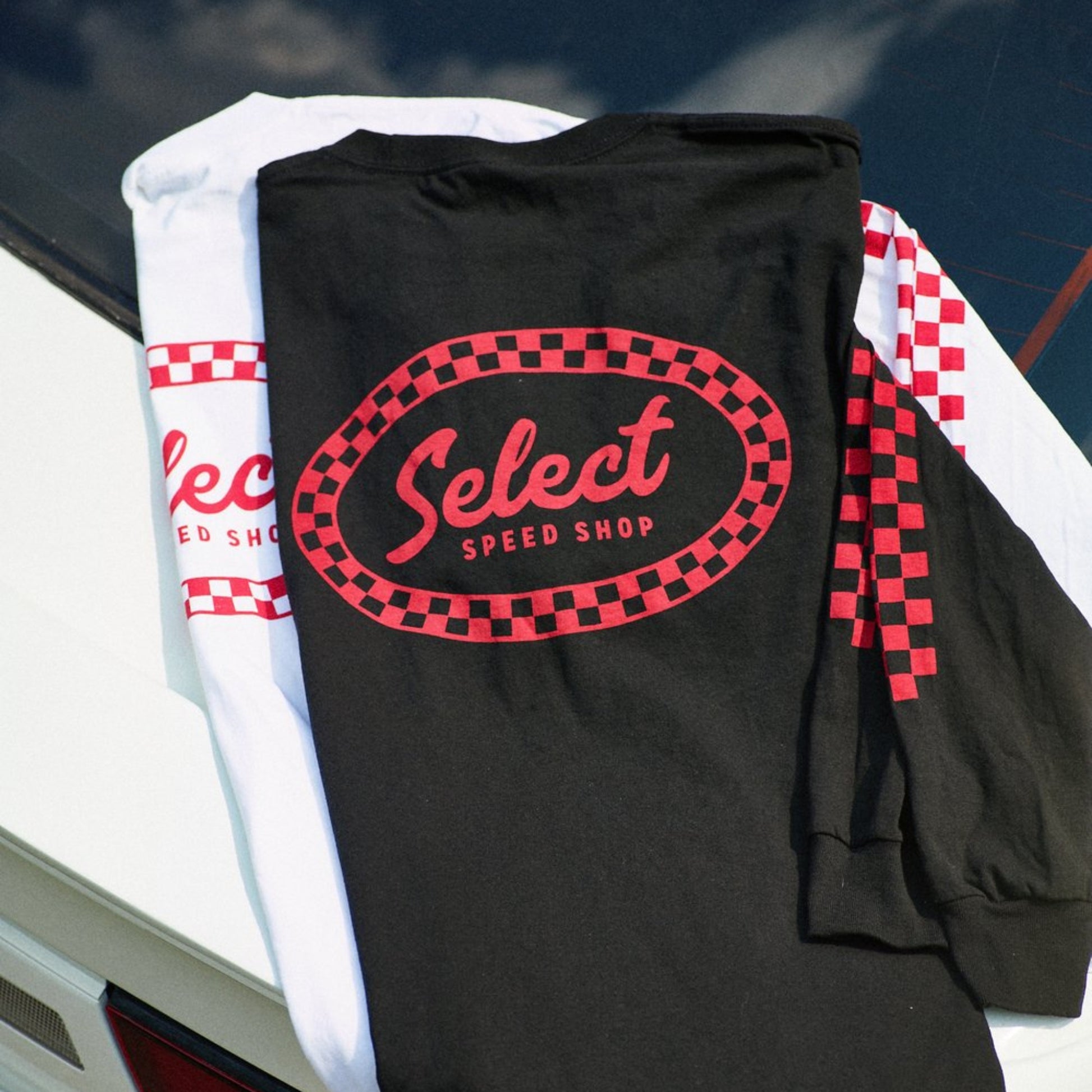 Black t-shirt with red and white checkered border and 'Select Speed Shop' logo on a car hood.