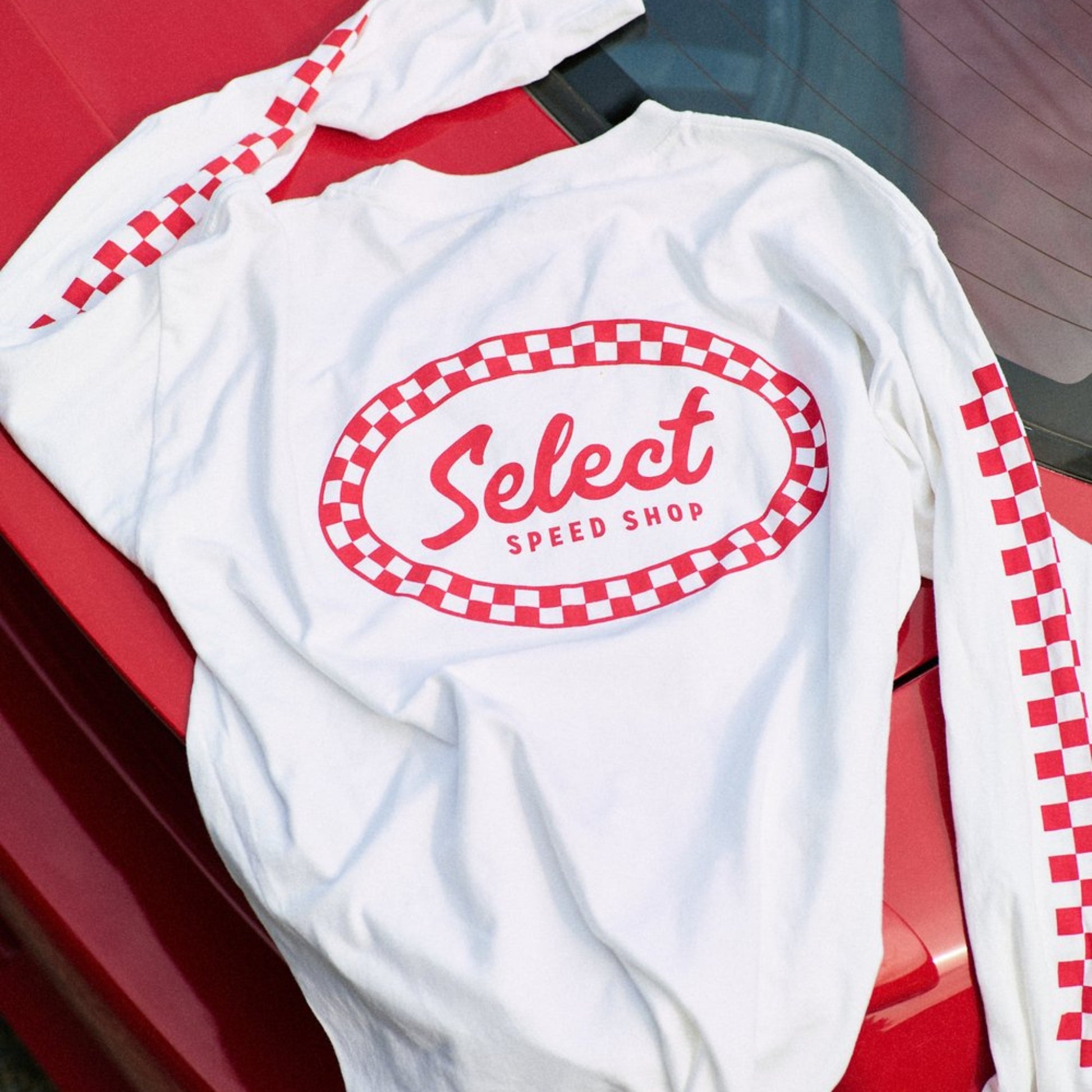 White sweatshirt with red checkered border and 'Select Speed Shop' text on a red car background