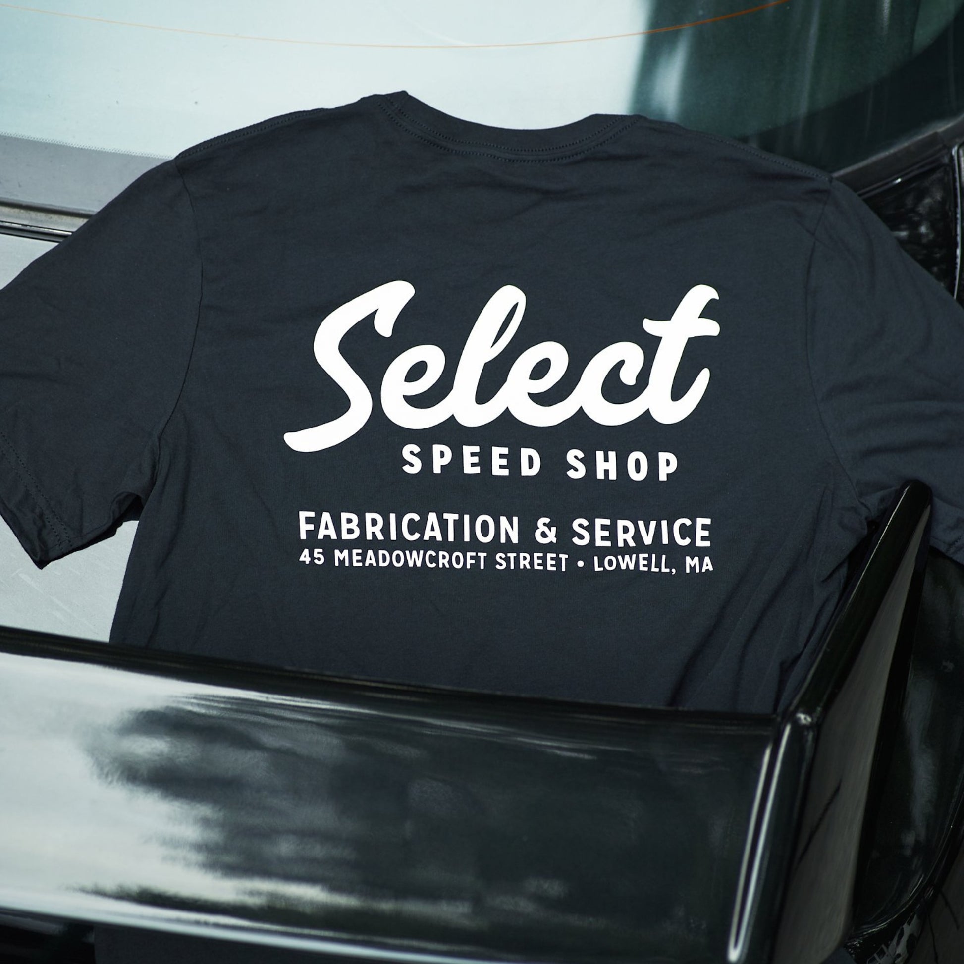 Black t-shirt with 'Select Speed Shop' text on a car hood
